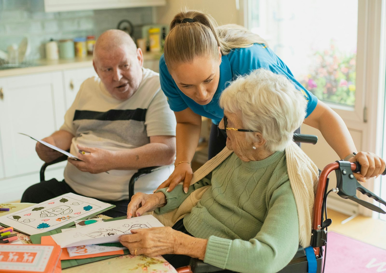 Home care aide assisting an elderly couple with an activity in their Altamonte Springs home